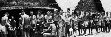 A group of prisoner of wars in a line up for a mess parade.